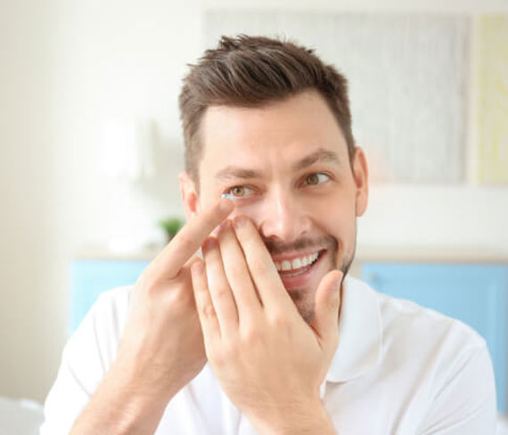 Man putting on contact lens