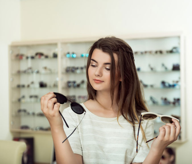 Woman picking out a pair of sunglasses at C Eyewear