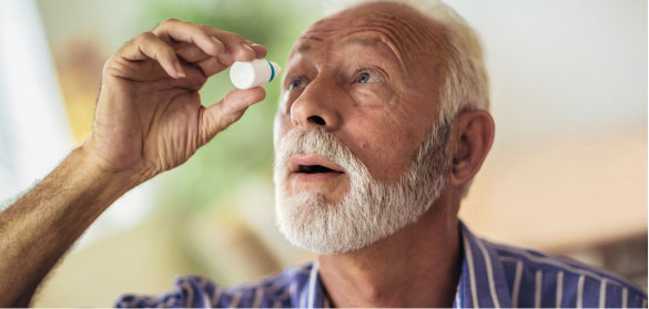 Man using eye drop on right eye