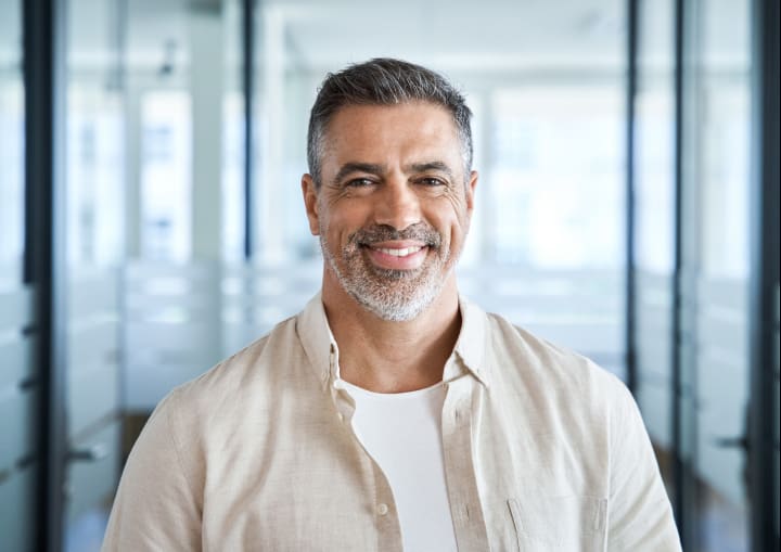 Man wearing beige shirt smiling